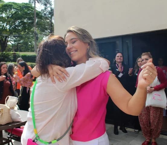Ju Romantini abraçando uma participante durante um encontro